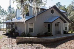 Gray two story bungalow with dormer windows