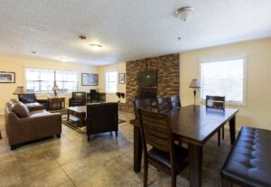 Tiled living and dining area with stone fireplace