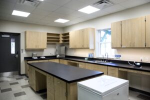 Lab area with slate counters and extensive cabinets, sink, fridge